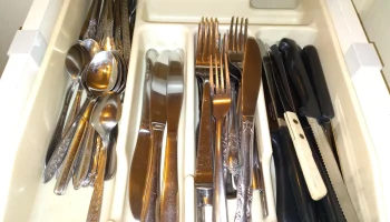 Крючок для удержания подноса с кухонной утварью в ящике.